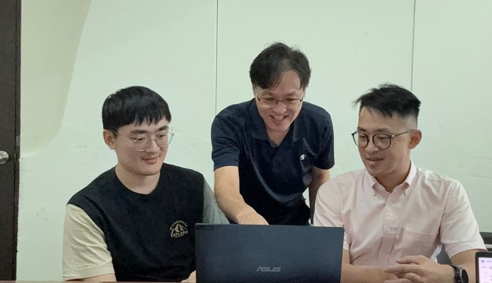 企業團隊圍繞筆電進行 AI 導入共創討論